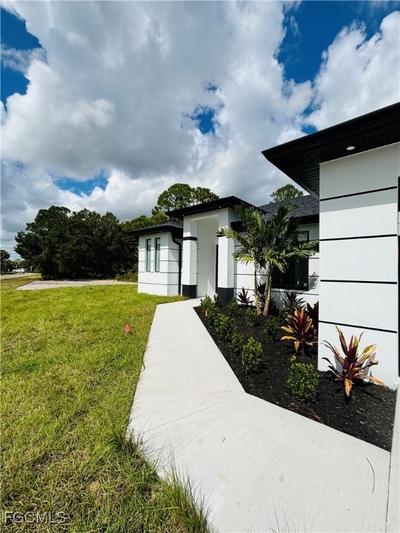 View of exterior entry with a lawn