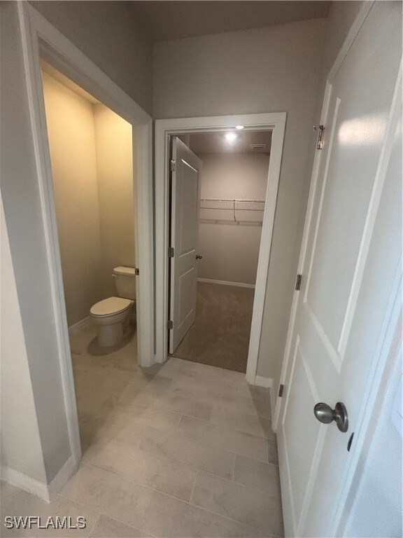 Bathroom featuring toilet and baseboards