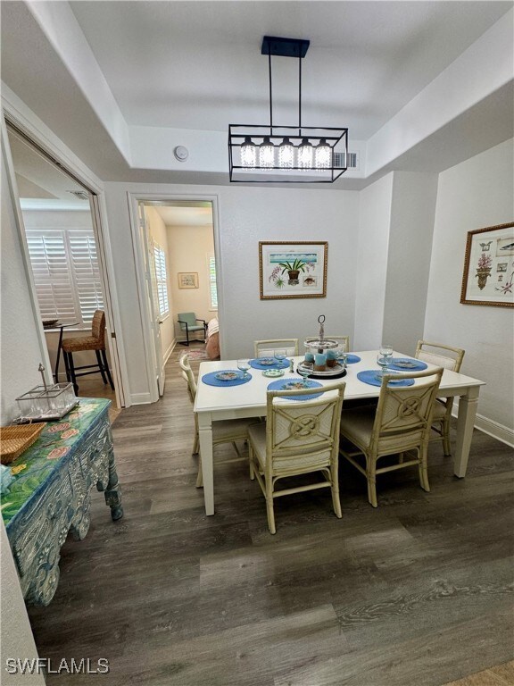 Dining area featuring dark wood-style flooring and