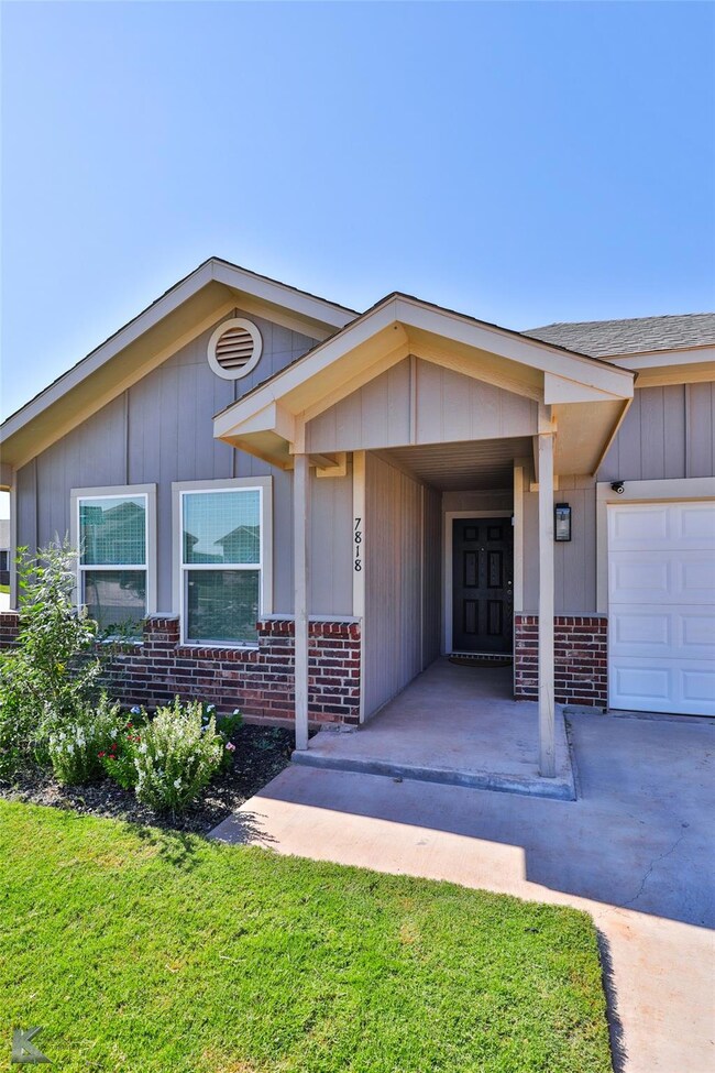 Property entrance with a lawn and a garage