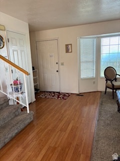 Foyer entrance with light wood finished floors and stairs