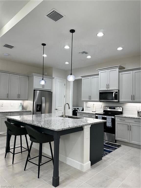 Kitchen with sink, refrigerator, range, hanging li