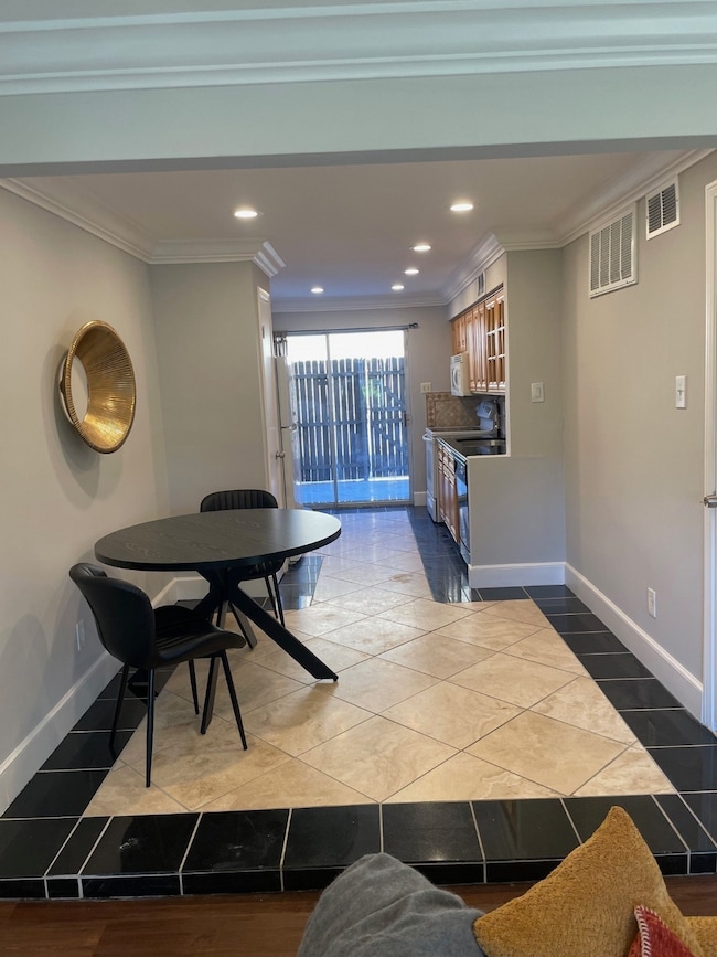 Dining area featuring recessed lighting, ornamental molding, and dark tile patterned flooring
