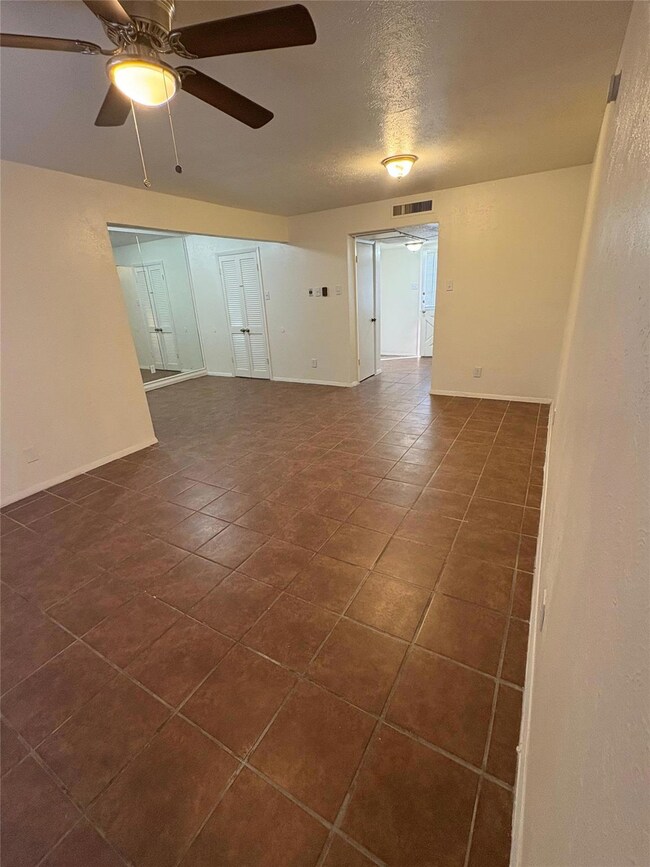 Living room featuring ceiling fan and a textured c