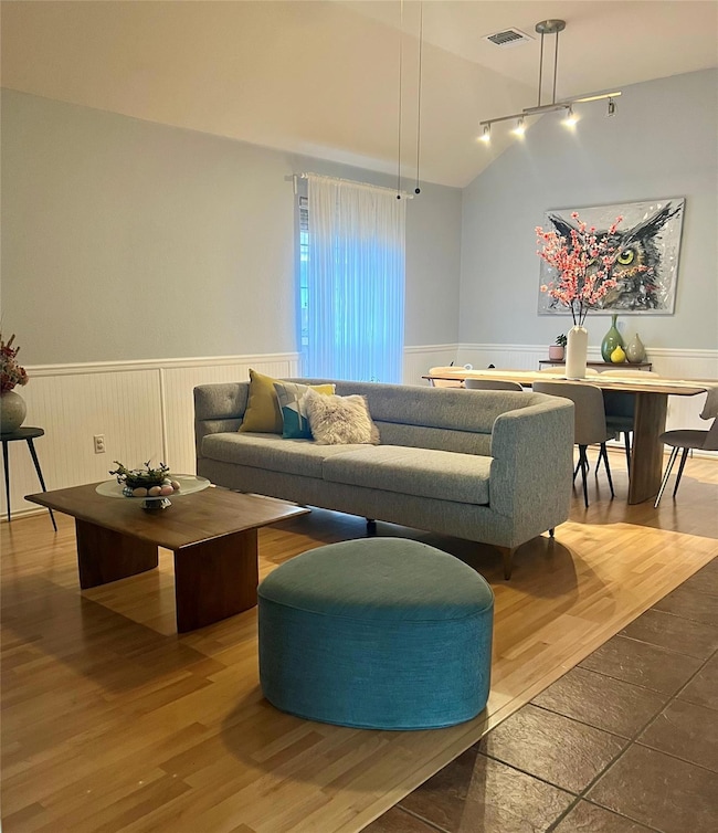 Living area with rail lighting, a wainscoted wall