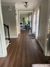 Hallway with crown molding, wood finished floors, and stairway