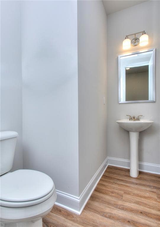 Bathroom featuring wood finished floors, toilet, a