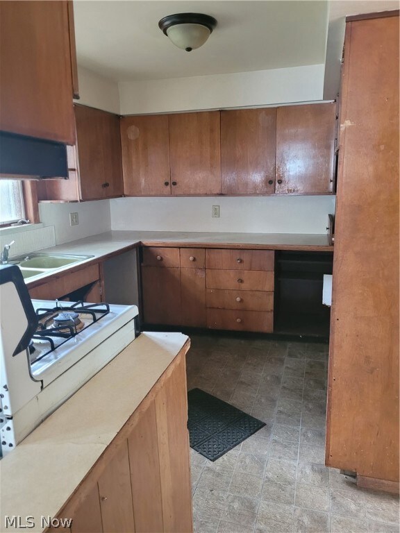 Kitchen featuring backsplash, sink, and light tile flooring