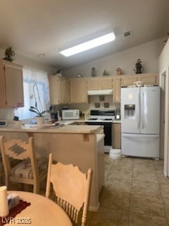 Kitchen featuring white appliances, exhaust hood,