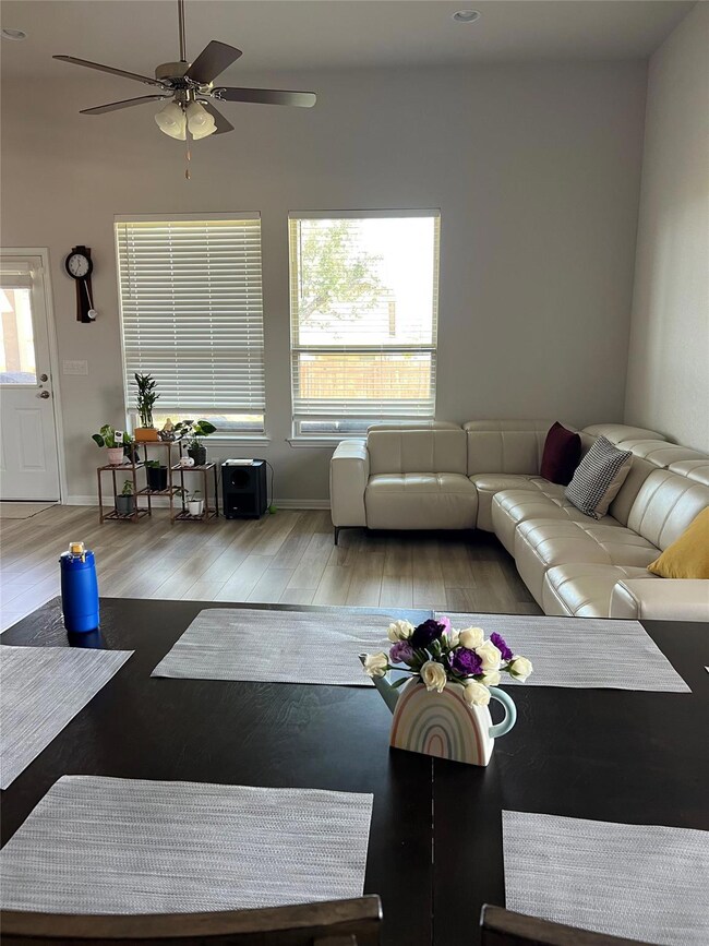 Living area featuring a ceiling fan, wood finishe