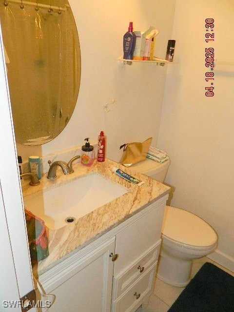 Full bath with toilet, tile patterned floors, vani