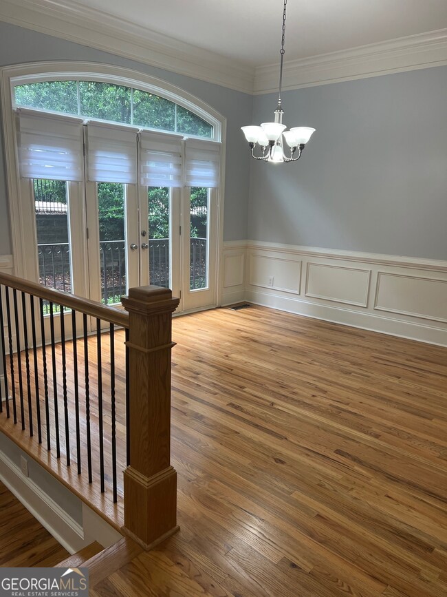 A beautiful front room featuring a dramatic transom and french doors flanked by stationary windows.