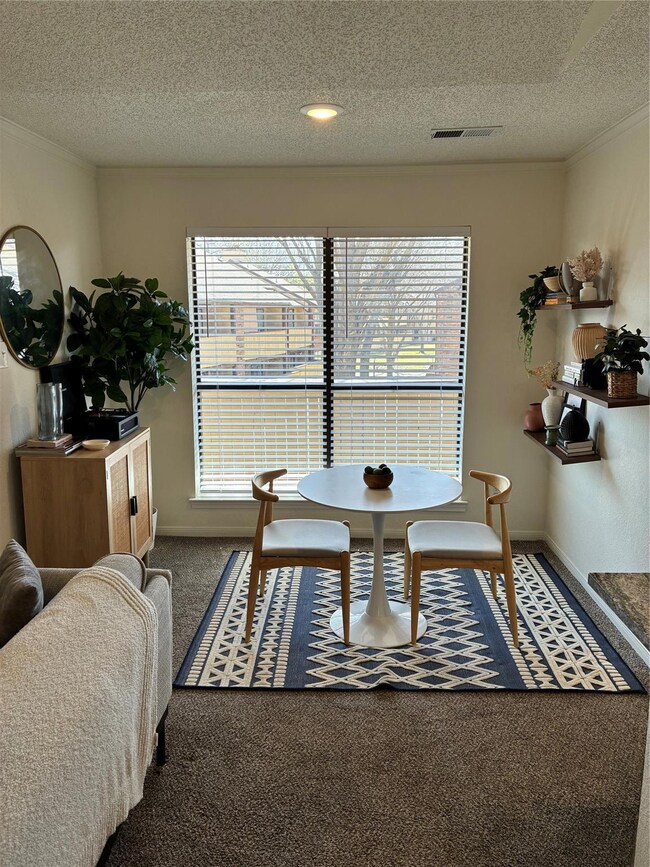 Carpeted dining room featuring visible vents, base