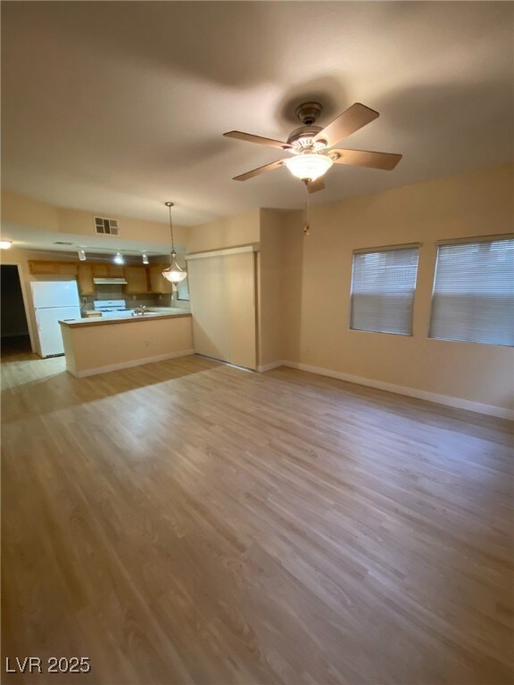 Unfurnished living room featuring light wood finished floors and a ceiling fan