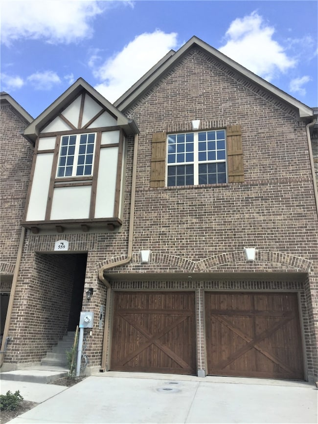 View of front of property featuring a garage, brick siding, and concrete driveway