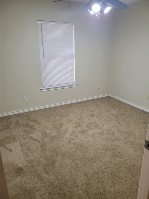 Carpeted empty room with baseboards and ceiling fa