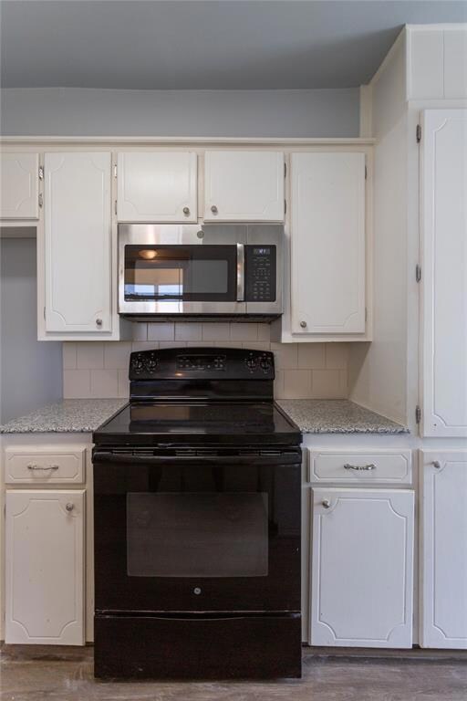 Kitchen with black / electric stove, backsplash, d