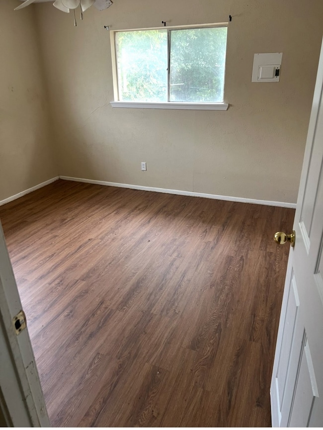 Bedroom featuring dark wood-style flooring and baseboards