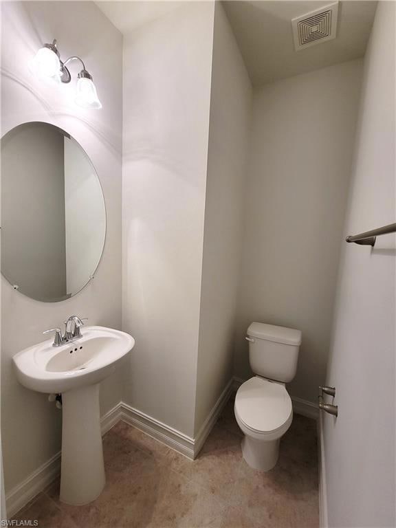 Bathroom featuring toilet, baseboards, a sink, and tile patterned flooring