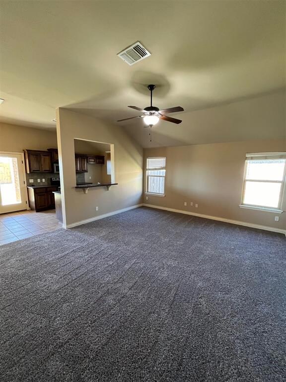 Unfurnished living room featuring light carpet, ce