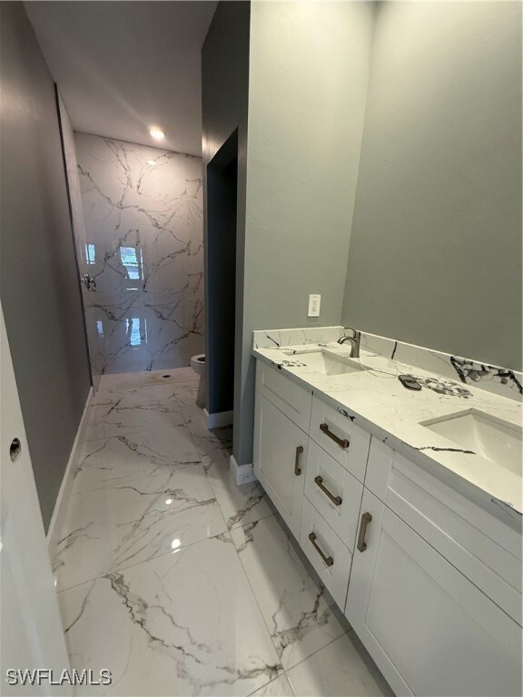 Bathroom with marble tiled floors, double vanity,