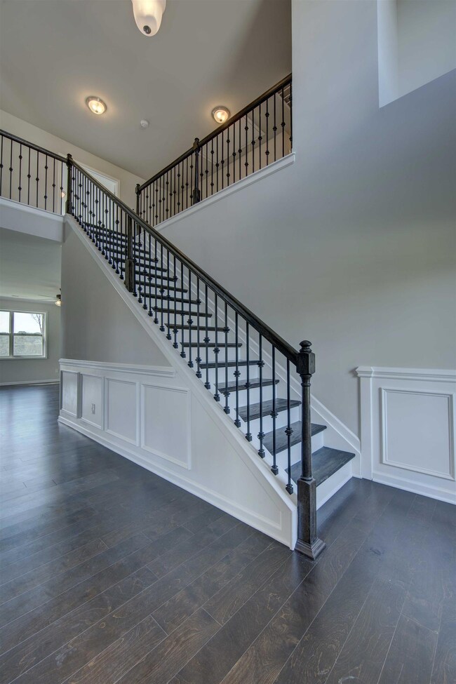 Elegant open stair case leads to open loft space.  All photos are representative of a similar home.