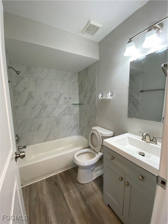 Full bathroom featuring wood finished floors, vani