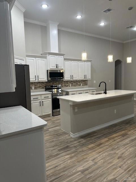 Kitchen with visible vents, arched walkways, a sink, refrigerator, and stove