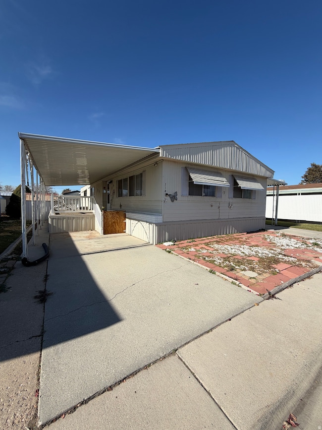 Manufactured / mobile home featuring concrete driveway and a carport