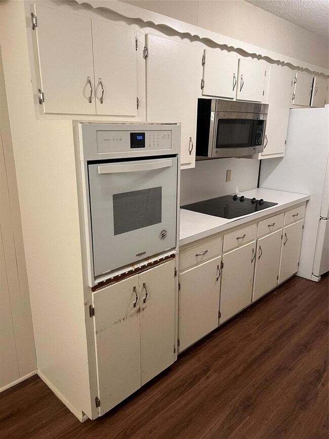 Kitchen with white cooktop, dark wood-type floorin