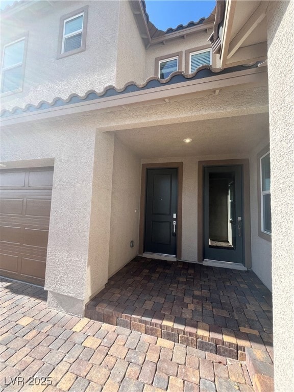 View of exterior entry featuring stucco siding, a