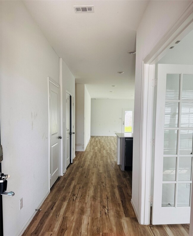 This photo shows a bright hallway with wood-look f