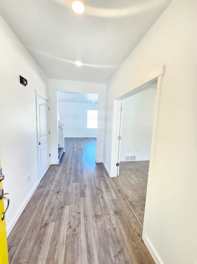 Corridor with light wood finished floors and baseboards