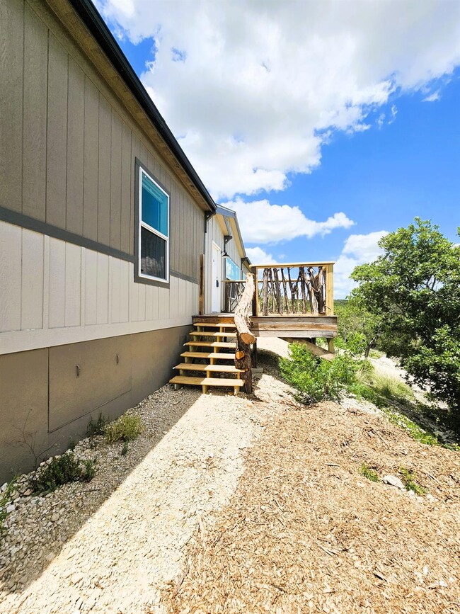 View of side of property with a wooden deck