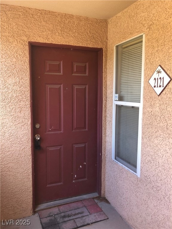 Entrance to property featuring stucco siding