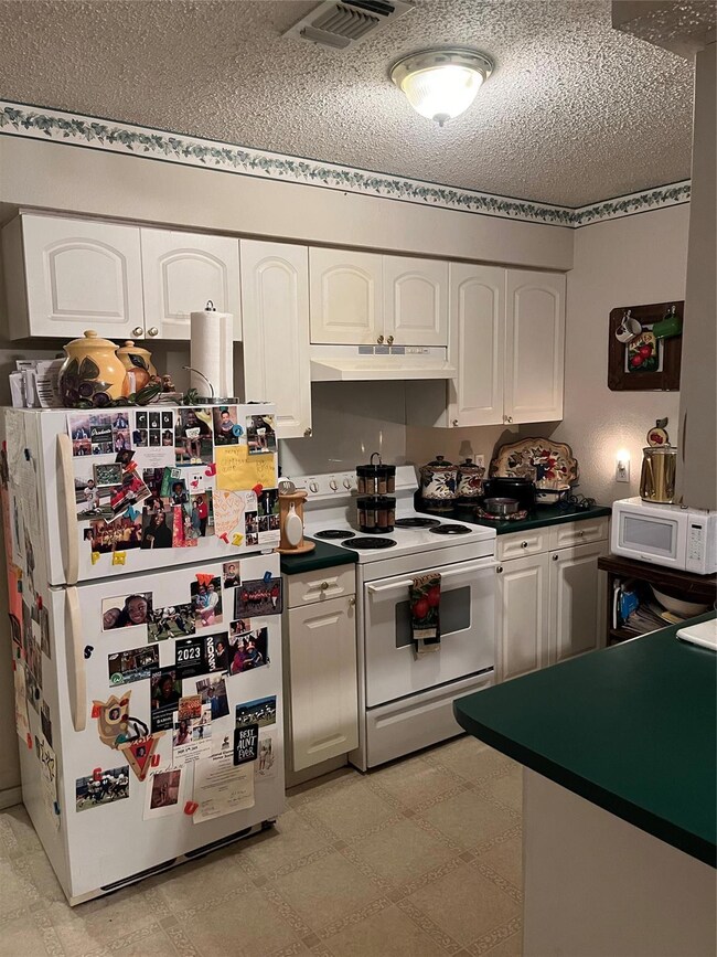 Kitchen featuring white range with electric cookto