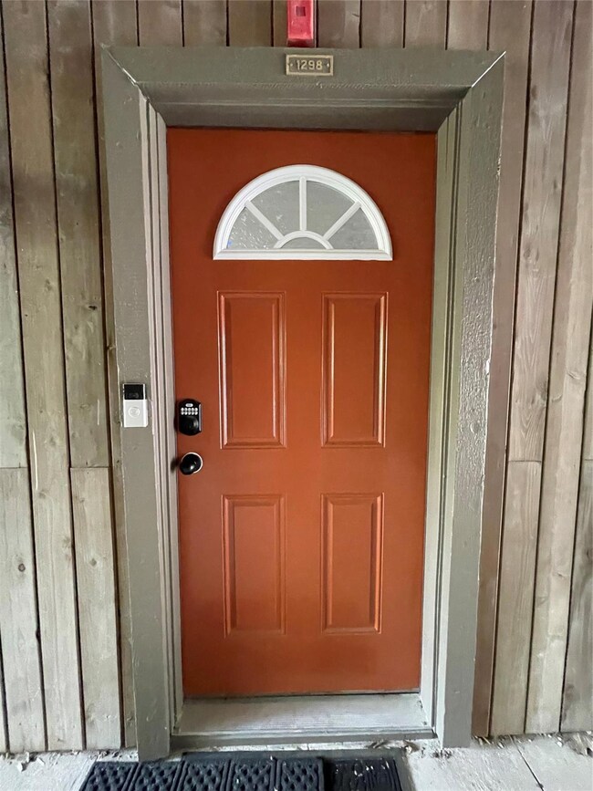 View of property front door with smart combo lock 