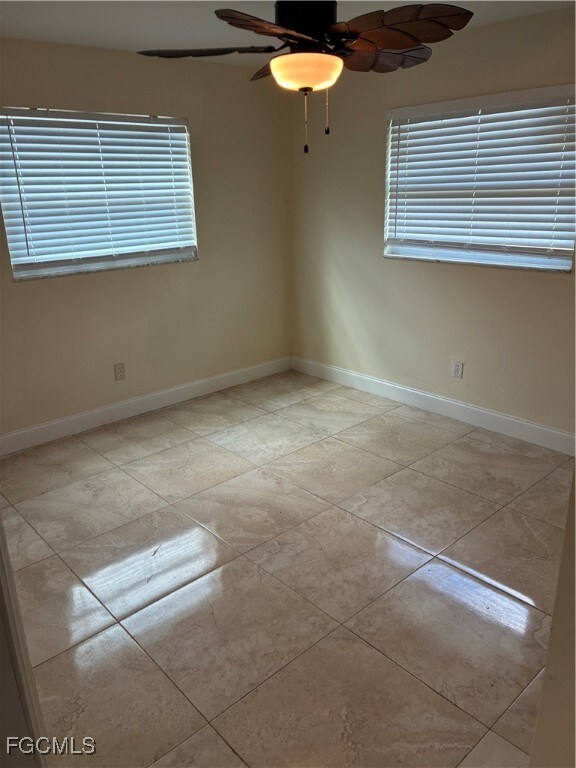 Empty room with baseboards and ceiling fan