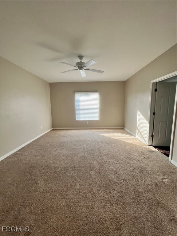 Empty room featuring ceiling fan and carpet