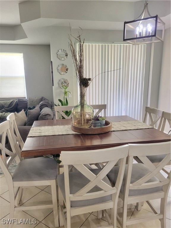 Dining room featuring a chandelier and light tile