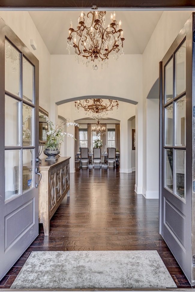Double entry doors, exquisite lighting, and beautiful architecture make this entry foyer the perfect place to welcome your guests. 