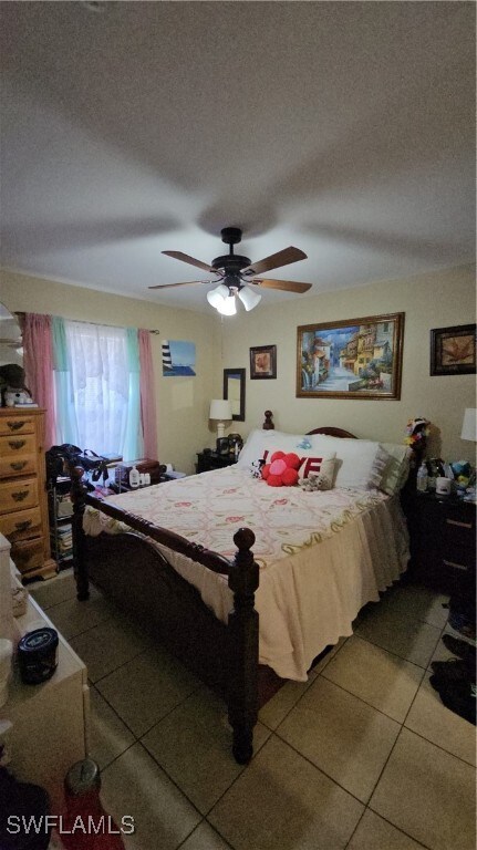 Tiled bedroom featuring a ceiling fan and a textur