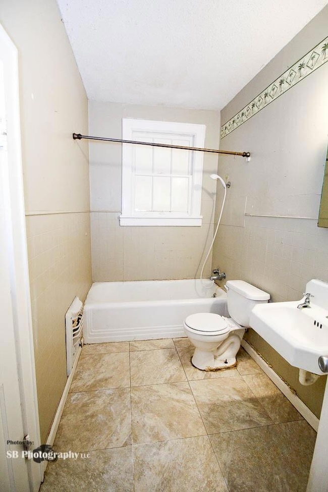 Full bathroom with sink, tile flooring, tiled show