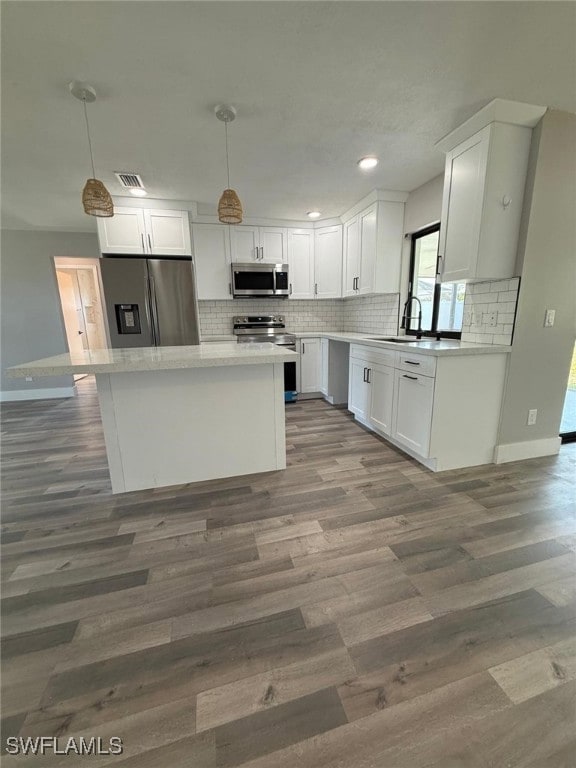 Kitchen featuring wood finished floors, a sink, wh