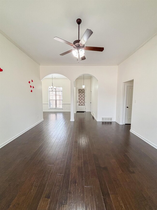 Unfurnished living room with arched walkways, dark