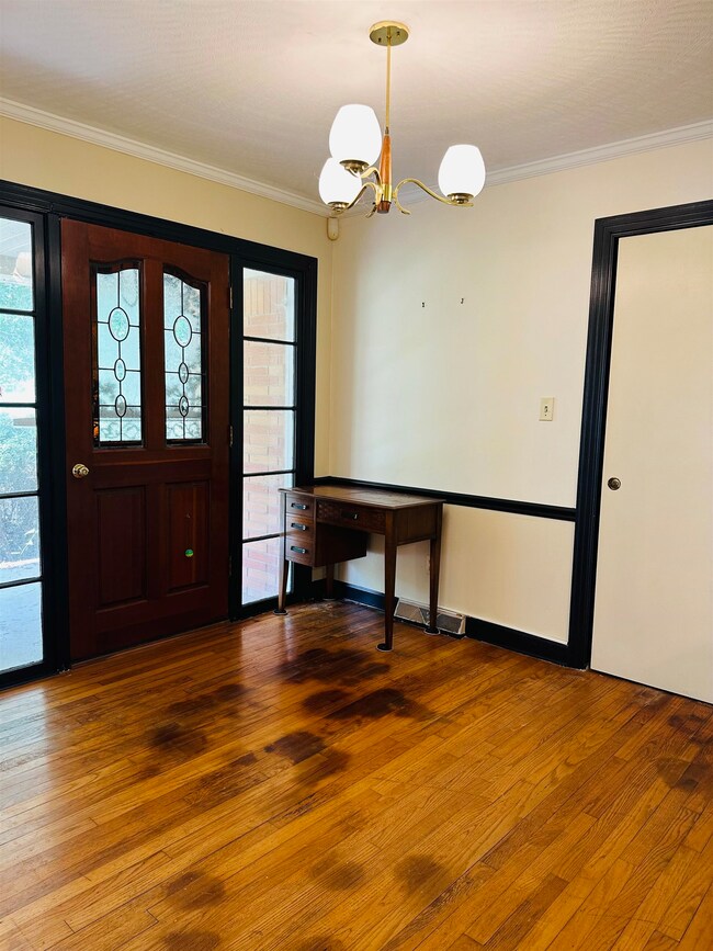 Entrance foyer with wood-type flooring, crown mold