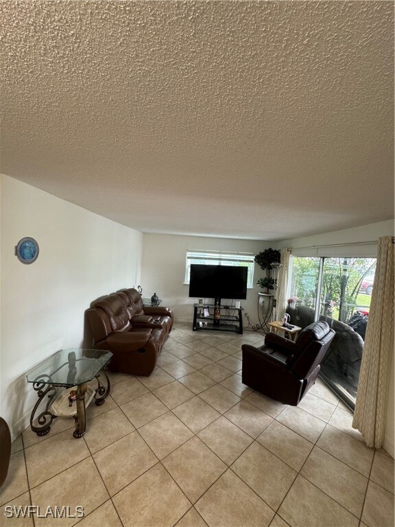Living room with a textured ceiling and light tile