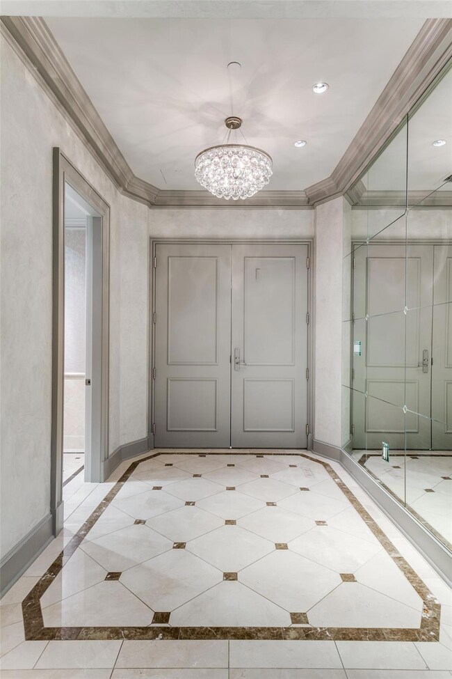 Corridor with ornamental molding and a chandelier