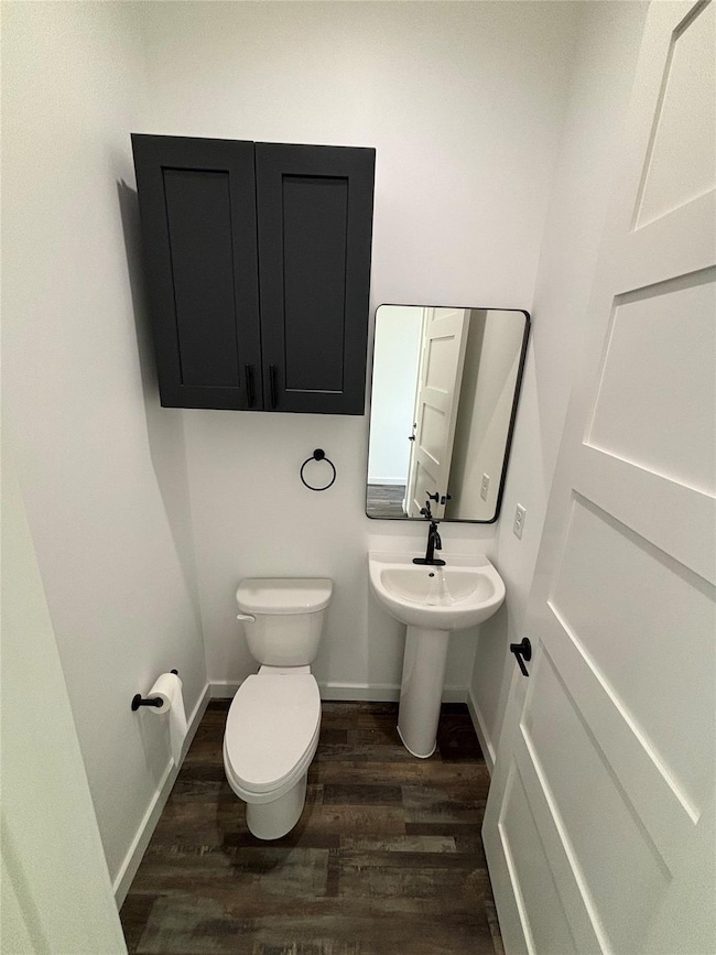 Bathroom featuring wood finished floors, toilet, 