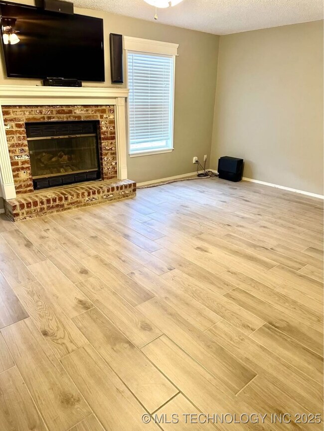 Unfurnished living room featuring wood finished fl